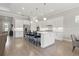 Spacious kitchen with stainless steel appliances, white cabinets, large island, and hardwood floors at 10136 Coral Shore Dr, Englewood, FL 34223