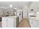 Modern kitchen featuring stainless steel appliances, a large island, and white cabinets at 10136 Coral Shore Dr, Englewood, FL 34223