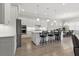 Modern kitchen featuring white cabinetry, stainless steel appliances, an island with bar stools, and pendant lighting at 10136 Coral Shore Dr, Englewood, FL 34223