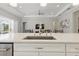 Bright kitchen island with stainless steel appliances and white cabinets, great for cooking and entertaining at 10136 Coral Shore Dr, Englewood, FL 34223