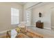 Bright and airy living room with a white armchair, and a decorative glass door in the background at 10136 Coral Shore Dr, Englewood, FL 34223