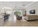 Open-concept living area with hardwood floors, a modern ceiling fan, and a view of the pool area at 10136 Coral Shore Dr, Englewood, FL 34223