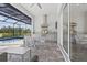 Outdoor kitchen featuring a gas grill, stainless steel hood vent and sink overlooking pool at 10136 Coral Shore Dr, Englewood, FL 34223
