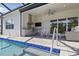Outdoor space with a full kitchen, pool access, and covered lounge area, perfect for entertaining at 10136 Coral Shore Dr, Englewood, FL 34223