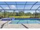 Swimming pool with attached blue tile hot tub in an enclosed screened in patio area at 10136 Coral Shore Dr, Englewood, FL 34223