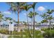 Community pool area with lounge chairs, greenery, signage and mature palm trees at 10136 Coral Shore Dr, Englewood, FL 34223