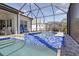Enclosed pool area with blue tile hot tub, open patio and ample seating for relaxing by the water at 10136 Coral Shore Dr, Englewood, FL 34223