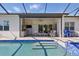 Beautiful pool featuring a screened-in lanai, outdoor kitchen, and patio furniture at 10136 Coral Shore Dr, Englewood, FL 34223