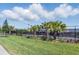 Community tennis courts lined with landscaping, palm trees and a black chain link fence at 10136 Coral Shore Dr, Englewood, FL 34223