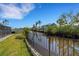 The waterfront backyard features a canal view and lush greenery, providing a peaceful and picturesque setting at 106 Playmore Dr, Venice, FL 34293