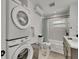 Renovated bathroom features stacked washer and dryer, bath tub and contemporary finishes at 106 Playmore Dr, Venice, FL 34293