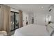 Bright bedroom with sliding glass doors to the patio and neutral design and furnishings at 106 Playmore Dr, Venice, FL 34293