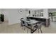 Open dining area featuring a modern table with seating for six, with an island bar with barstools at 106 Playmore Dr, Venice, FL 34293