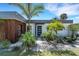 Modern home featuring a stylish exterior with wood accents, landscaping and well-maintained lawn at 106 Playmore Dr, Venice, FL 34293