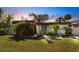 Charming single-story home with manicured lawn, modern design, and lush landscaping at 106 Playmore Dr, Venice, FL 34293