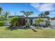 Modern home featuring a stylish exterior with wood accents, landscaping and well-maintained lawn at 106 Playmore Dr, Venice, FL 34293