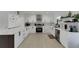 Well-lit kitchen boasts sleek white cabinets, modern appliances, and stylish tile backsplash at 106 Playmore Dr, Venice, FL 34293