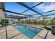 Inviting screened-in pool area features a sparkling pool, modern patio, and comfortable lounge chairs, perfect for relaxation at 106 Playmore Dr, Venice, FL 34293