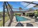 This screened-in pool area features a sparkling pool, outdoor kitchen, and comfortable lounging space for ultimate relaxation at 106 Playmore Dr, Venice, FL 34293