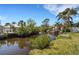 Waterfront view of the property showcasing serene canal, lush greenery, and private dock, ideal for boating enthusiasts at 106 Playmore Dr, Venice, FL 34293