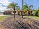 Charming single story home featuring mature palms, a two-car garage and a covered front porch at 1101 Southland Rd, Venice, FL 34293