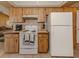 Traditional-style kitchen featuring white appliances and wooden cabinets with tile countertops at 1101 Southland Rd, Venice, FL 34293