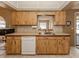 Traditional kitchen with wooden cabinets, tile countertops, and a stainless steel sink at 1101 Southland Rd, Venice, FL 34293
