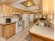 Efficient kitchen with matching appliances, laminate counters, tile backsplash, and wooden cabinets at 1101 Southland Rd, Venice, FL 34293