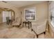 Cozy living room featuring travertine floors, seating area, and large windows with natural light at 1101 Southland Rd, Venice, FL 34293