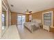Spacious main bedroom with light tile flooring, ceiling fan, dresser, and sliding glass door access at 1101 Southland Rd, Venice, FL 34293