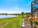 Lush backyard with a serene lake view and manicured landscaping at 11343 Bertolini Dr, Venice, FL 34292