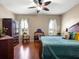 Comfortable bedroom featuring a wood floor, light-colored walls and a ceiling fan at 11343 Bertolini Dr, Venice, FL 34292