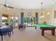Inviting game room features a billiards table and card tables with a view of the community pool at 11343 Bertolini Dr, Venice, FL 34292