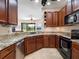 Stylish kitchen features granite counters, stainless appliances, wood cabinets and views of the living room at 11343 Bertolini Dr, Venice, FL 34292