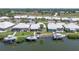 Aerial view of a waterfront community with private docks, boat lifts, and well-maintained homes at 120 Villa Dr # 120, Osprey, FL 34229