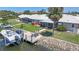 Backyard view featuring a dock with a boat lift, screened lanai, and lush landscaping at 120 Villa Dr # 120, Osprey, FL 34229