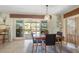 Dining area with a modern light fixture, seating for four, and sliding glass doors to the outdoor space at 120 Villa Dr # 120, Osprey, FL 34229