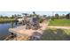 Wooden dock with tiled patio and seating overlooks the water and nearby boats at 120 Villa Dr # 120, Osprey, FL 34229