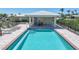 Community pool with covered patio, lounge chairs, and secure fencing at 120 Villa Dr # 120, Osprey, FL 34229