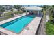 Aerial view of community pool with covered patio, lounge chairs, and secure fencing at 120 Villa Dr # 120, Osprey, FL 34229