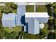 Aerial view of a light blue home with a gray roof, complemented by a matching garage and lush landscaping at 121 Dolly St, Punta Gorda, FL 33950