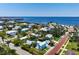 Aerial view of a light blue home near the coast, surrounded by mature trees and other residential properties at 121 Dolly St, Punta Gorda, FL 33950