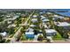 Aerial view of light blue two-story home in a charming neighborhood shows metal roof, green grass, and a detached garage at 121 Dolly St, Punta Gorda, FL 33950