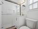 Updated bathroom features white tiled shower, new vanity and a round mirror at 121 Dolly St, Punta Gorda, FL 33950
