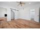 Open bedroom concept with wood flooring, barn door closet, and bathroom access at 121 Dolly St, Punta Gorda, FL 33950