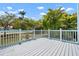 Outdoor deck with white railings, overlooking lush landscaping and a sunny blue sky at 121 Dolly St, Punta Gorda, FL 33950