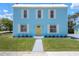 Charming two-story home with a light blue exterior, white trim, yellow door, and well-manicured lawn at 121 Dolly St, Punta Gorda, FL 33950