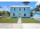 Charming light blue two-story home with a bright yellow door and crisp white trim, enhancing its curb appeal at 121 Dolly St, Punta Gorda, FL 33950