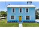 Charming two-story home with a light blue exterior, white trim, yellow door, and well-manicured lawn at 121 Dolly St, Punta Gorda, FL 33950