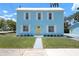 Charming light blue two-story home with a bright yellow door and crisp white trim, enhancing its curb appeal at 121 Dolly St, Punta Gorda, FL 33950